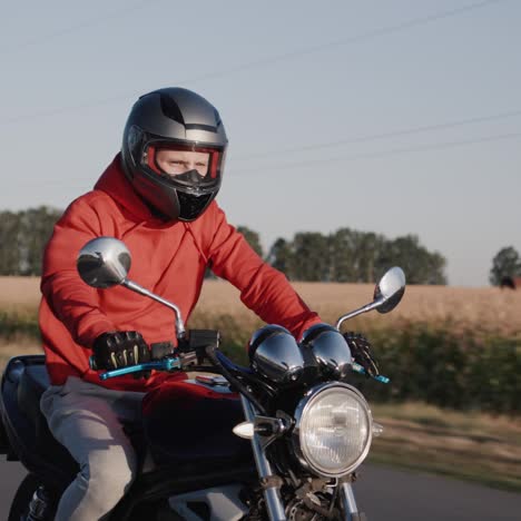 a young man rides a motorbike along corn fields 1