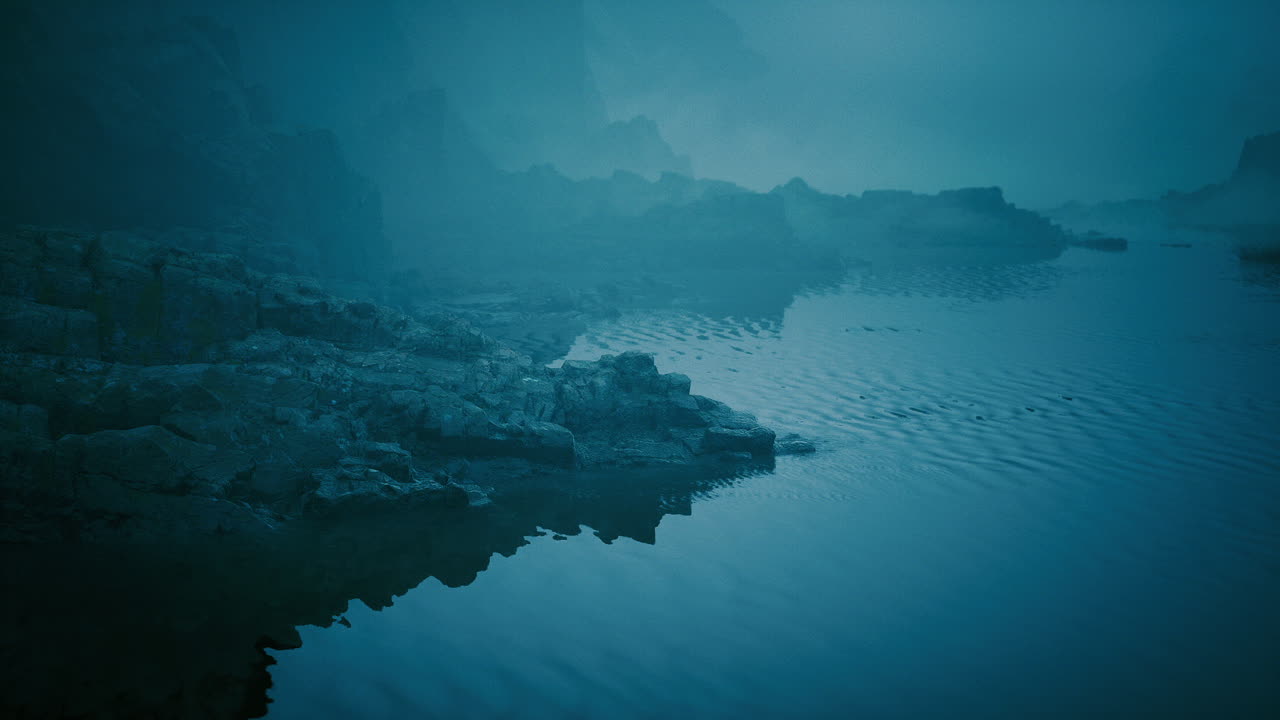 Misty waters reflect rocky shores in a tranquil landscape at dusk