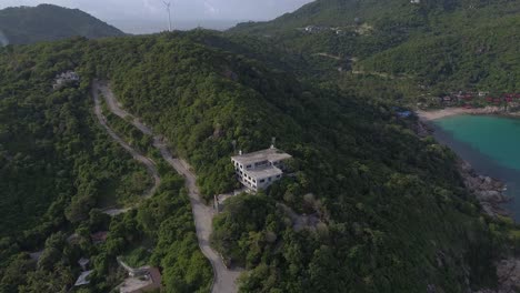 aerial view of a tropical island with a beach and a building on a hill