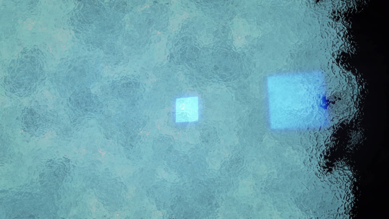 Glowing blue squares creating abstract pattern through textured glass surface