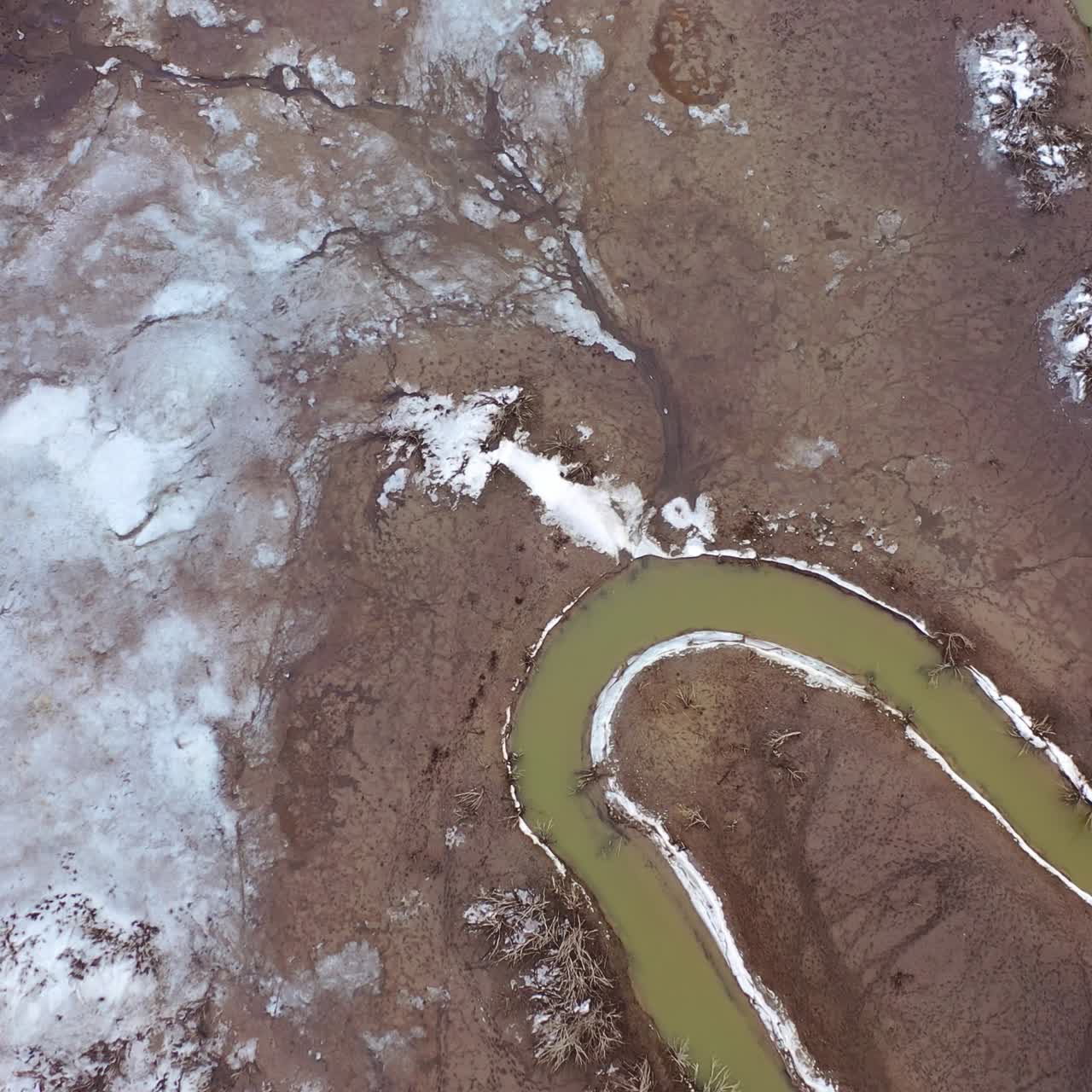 Muddy background with dirty stream. Ecology in danger. Polluted river in dried place. Disappearance of water. Aerial view