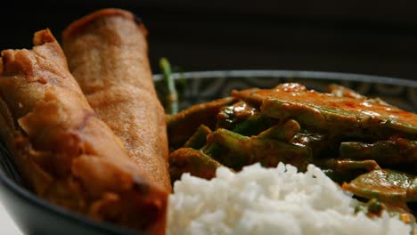 sartén lenta de curry rojo tailandés vegano con arroz y rollos de primavera