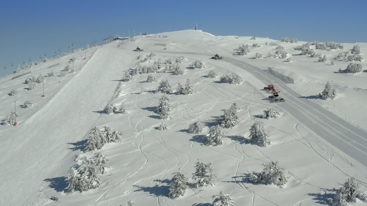 Snow Groomers on a Pristine Ski Slope in a Winter Mountain Landscape