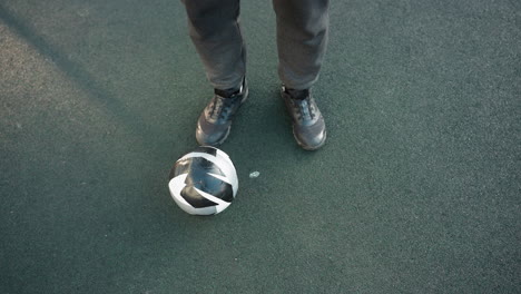 overhead view of athlete demonstrating controlled ankle movements with soccer ball on ground, focusing on precise foot placement and agility