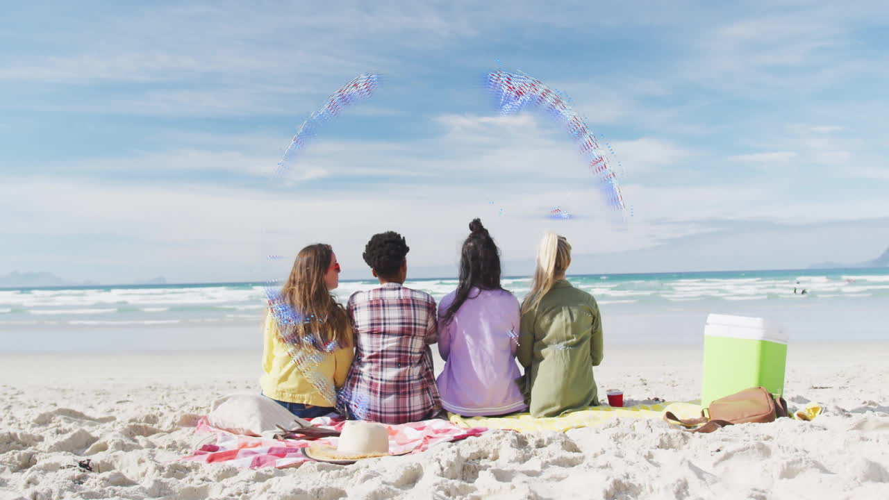 Four people sitting on beach, facing ocean, with colorful animation overhead