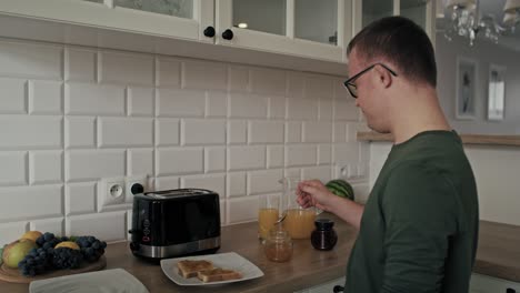 adult caucasian man with down syndrome preparing and passing breakfast to his mom