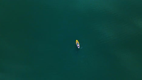 Stunning-aerial-4K-drone-footage-of-a-kayaker-paddling-through-a-tranquil-lake