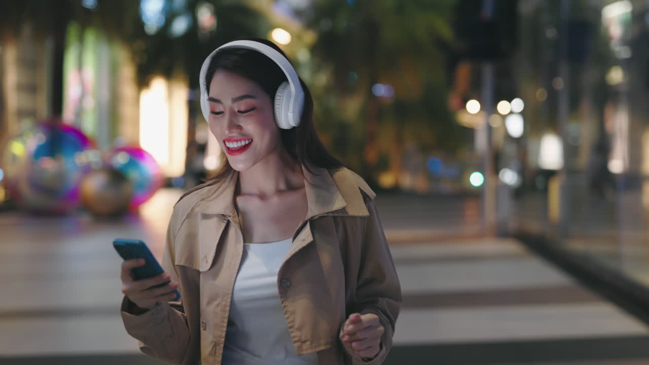 Happy Woman Listening to Music in a City at Night