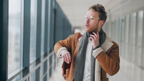 handsome curly man wears headphones and listens to music