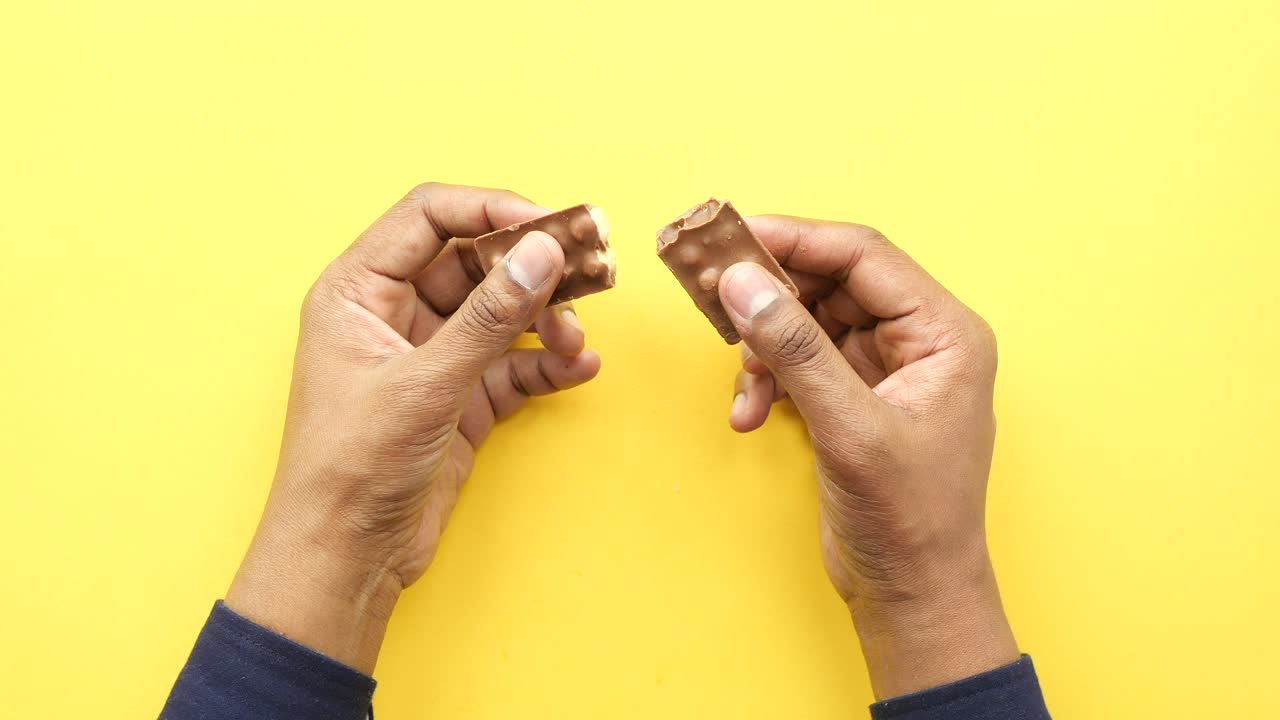 깨진 초콜릿 바를 들고 있는 손