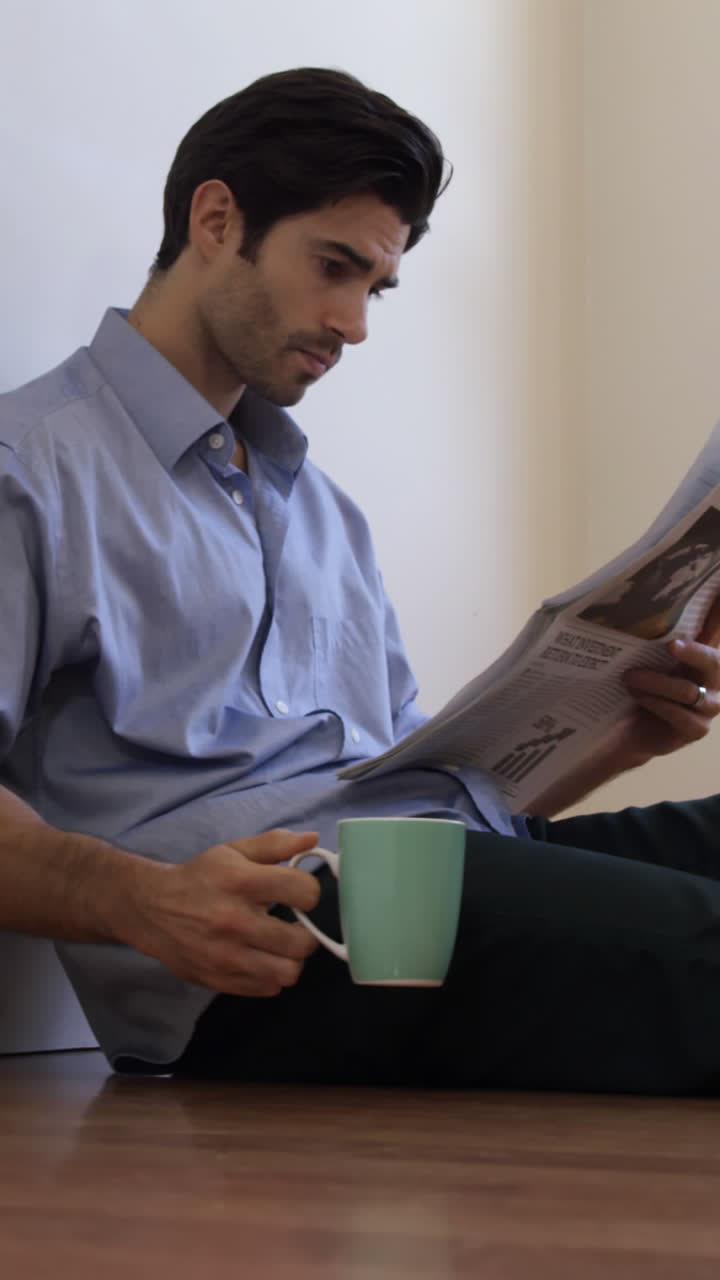 hombre leyendo el periódico mientras toma café
