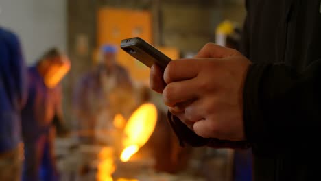 male worker using mobile phone in workshop 4k
