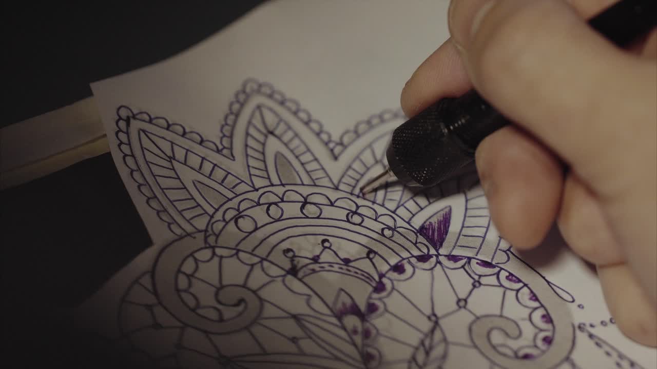 Tatuatore che disegna un nuovo tatuaggio
