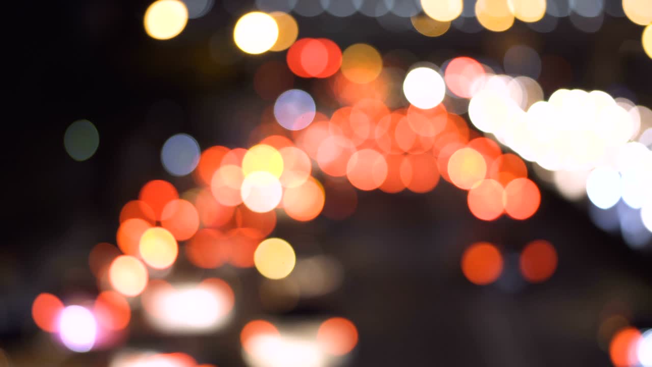 hermoso bokeh redondo colorido de los faros de los coches en la carretera por la noche