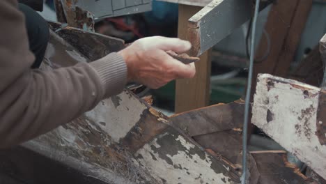 boat restoration carpenter breaks off mahogany planking for replacement