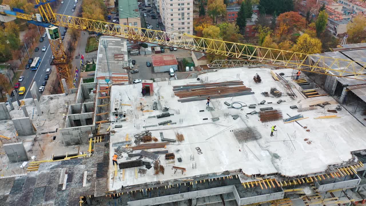 Aerial view of a new construction site. Top view on a roof of high-rise building in autumn on the city background.