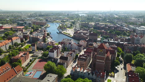 aerial view of gdansk town hall with ambersky ferris wheel beyond the motlawa river in poland