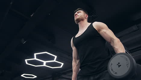 fitness man with dumbbells in gym. young man doing workout in luxury fitness club