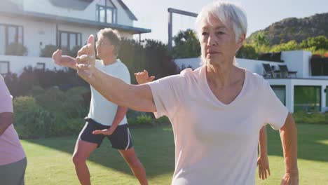 Senior-diverse-people-exercising-in-garden-on-sunny-day-at-retirement-home