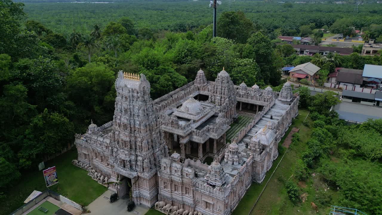 Ngoại thất ngôi đền Hindu được trang trí công phu với gopuram cao chót vót, những hình chạm khắc tinh xảo và tượng, bao quanh bởi phong cảnh xanh mát. Góc nhìn từ trên cao kỳ ảo, toàn cảnh tĩnh từ máy bay không người lái lơ lửng.