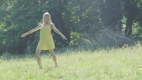 woman in yellow dress dancing gracefully in summer park