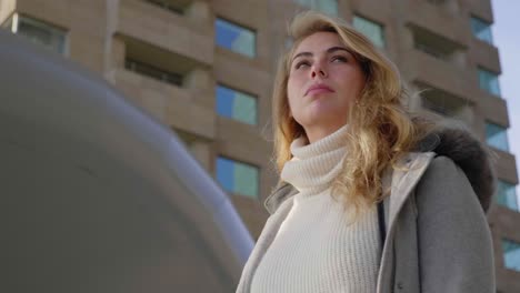 low angle shot of a confident stylish blonde woman, downtown city setting