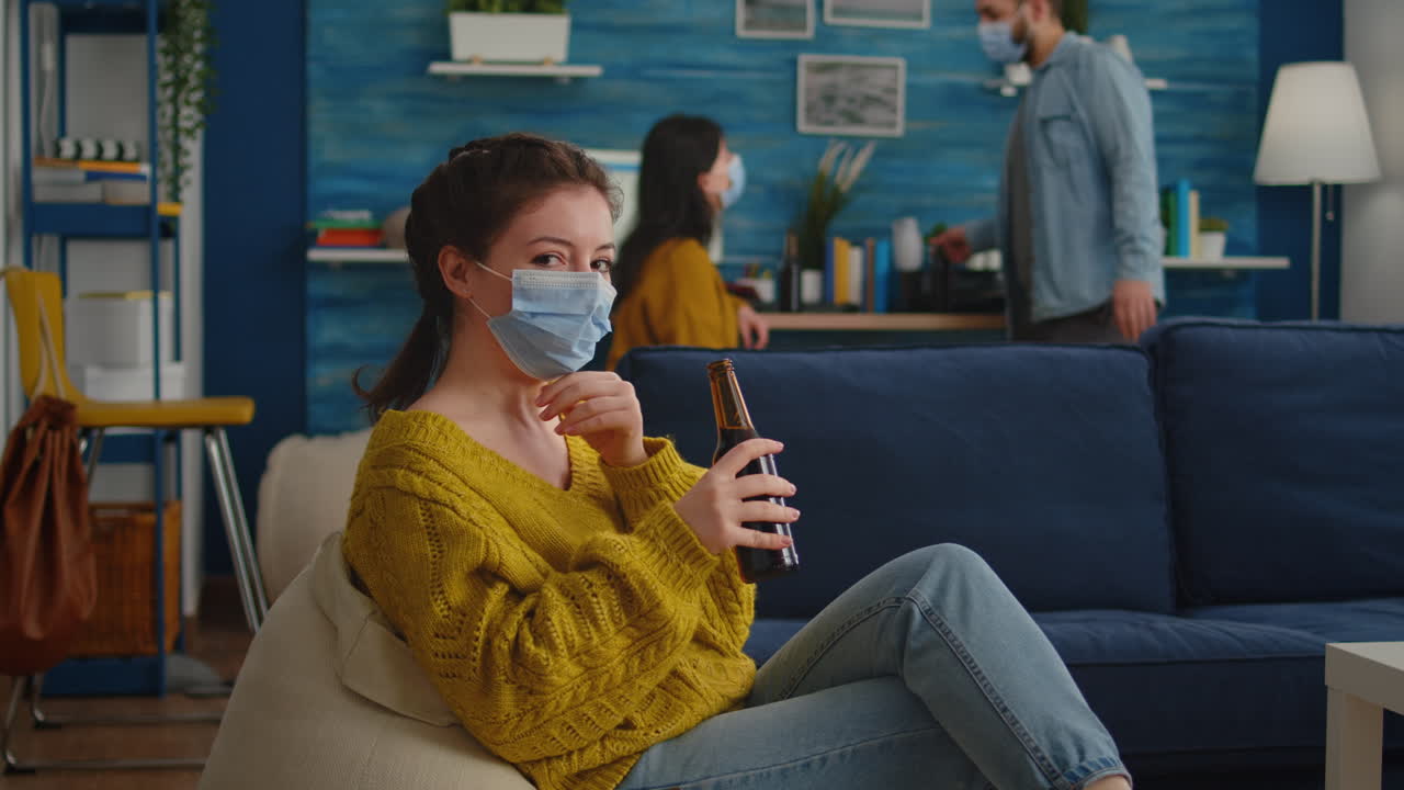 Pretty lady taking off protection face mask looking at camera
