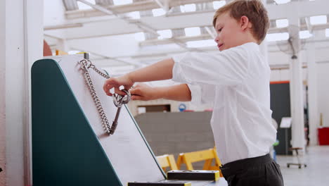 young boy doing practical puzzle at science activity centre