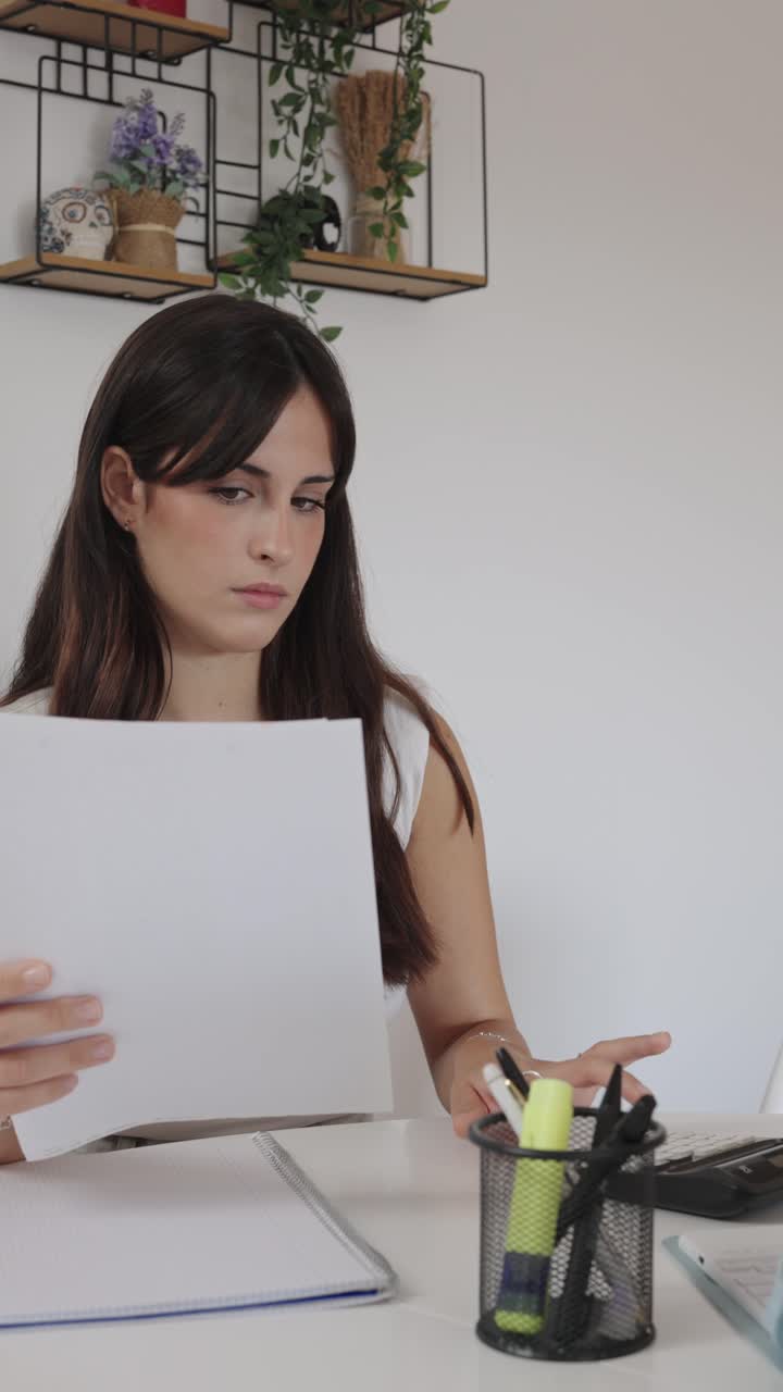 Woman working at desk with documents and calculator