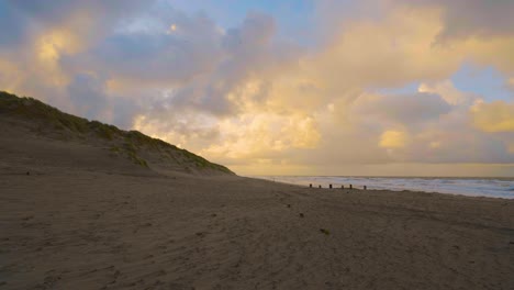 Sandy-beach-under-a-sky-with-contrasting-clouds-on-a-sunset