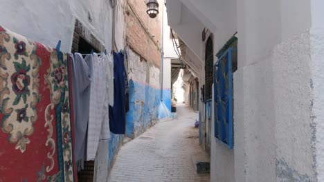 tánger, marruecos: pintoresco callejón en medina con ropa colgada y puertas antiguas