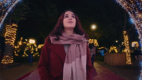 girl walks through a beautiful tunnel of christmas lights slow motion shot