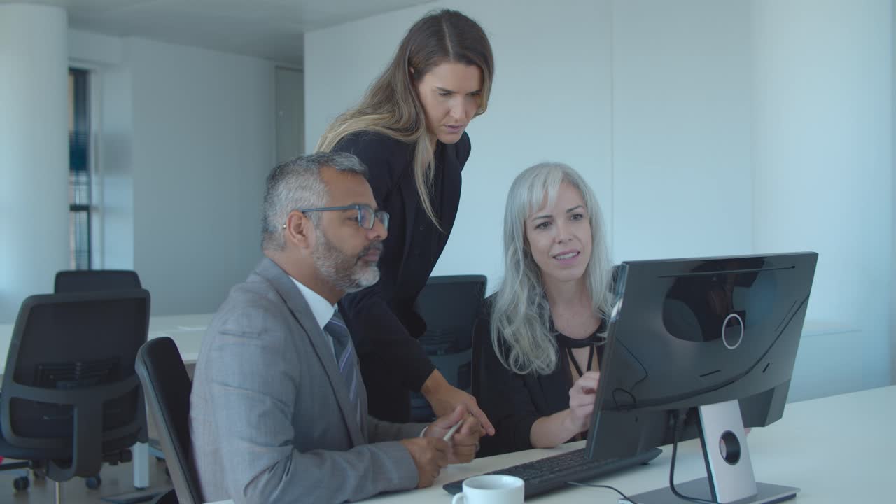 colegas viendo y discutiendo la presentación en el monitor