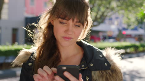 una mujer de moda usando su teléfono afuera en una ciudad