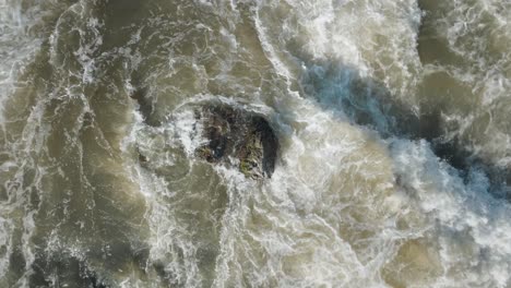 Turbulent-waters-cascading-over-rocks-at-owen-sound-waterfall-in-canada,-aerial-view