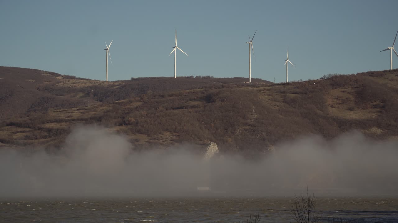 안개 속의 강 뒤 언덕 위의 풍차