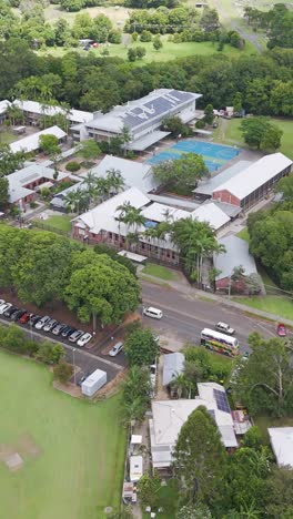 lush greenery surrounds a community school and fields