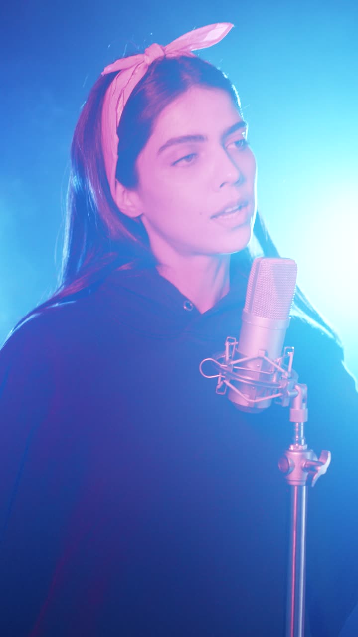 Young female singer performing into a vintage microphone. Vertical