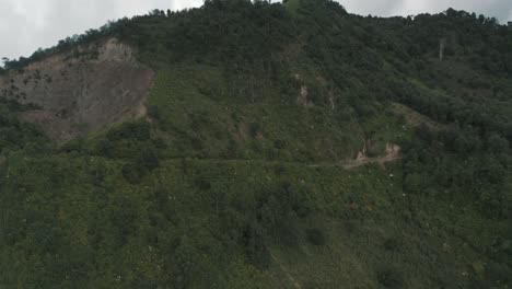 Drone-aerial-view-of-a-misty-mountain-and-a-green-park-during-cloudy-day