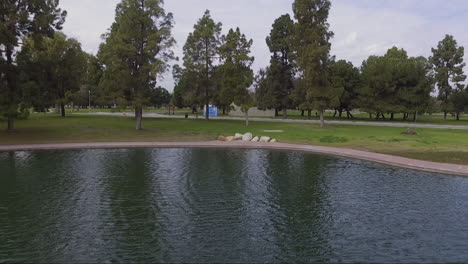 Drone-flight-over-pond-in-the-park