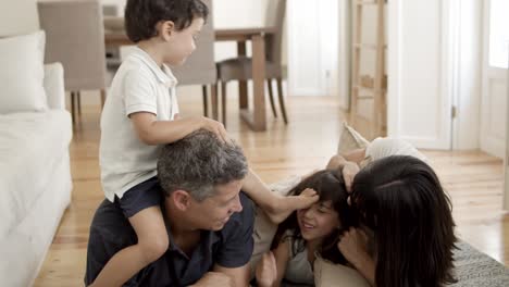 joyful family with two kids relaxing at home