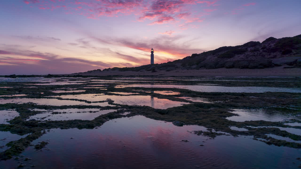 hermoso y colorido lapso de tiempo de la puesta de sol en el faro de faro de trafalgar, cádiz, españa