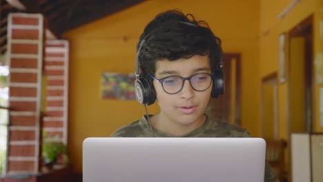 indian male student interacting during online group class activity using laptop