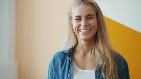 smiling woman in front of colorful wall