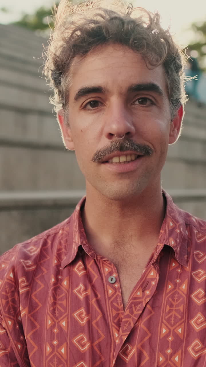 Jovem com Bigode e Cabelo Encaracolado Sorrindo para a Câmera