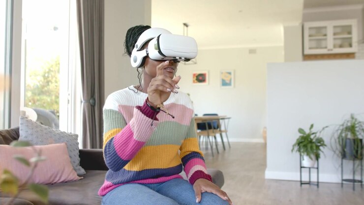 Video verticale: Donna in maglietta a righe con occhiali che indica, con visore VR, alza il dito e tocca un'interfaccia AR sovrapposta sul divano.