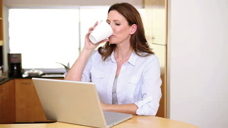 Mujer-Tomando-Un-Café-Frente-A-Su-Computadora-Portátil