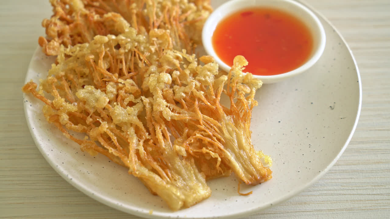 deep fried enoki mushroom or golden needle mushroom with spicy dipping sauce - vegan food style
