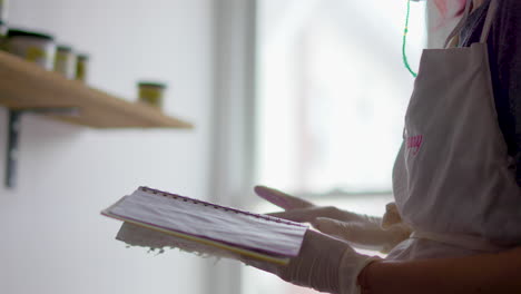 artista en su estudio hojeando su cuaderno