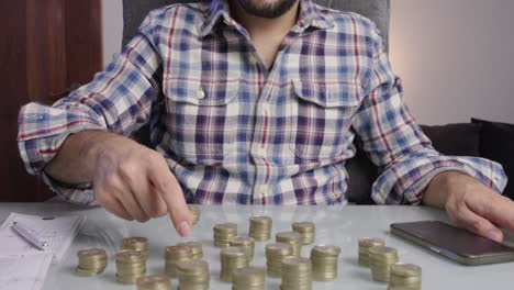 man drops coins one by one counts coins doing accounting